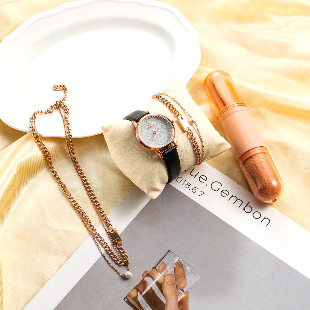 Detta fyrdelade presentset för damer kombinerar en stilren quartzklocka med matchande smycken och en makeupborste, vilket gör det till en komplett och elegant gåvobox.