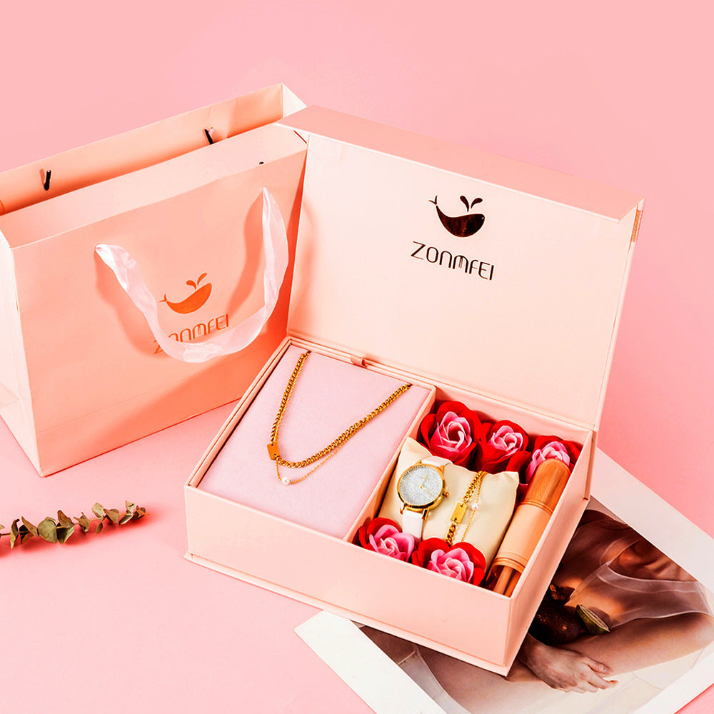Detta fyrdelade presentset för damer kombinerar en stilren quartzklocka med matchande smycken och en makeupborste, vilket gör det till en komplett och elegant gåvobox.